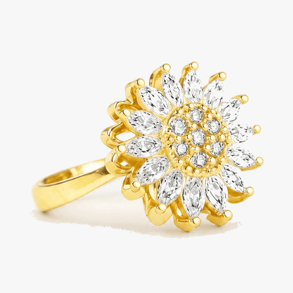 Justerbar fidgetring i guld med drejeligt solblomst-motiv og klare sten