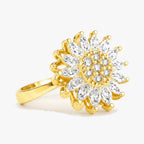 Justerbar fidgetring i guld med drejeligt solblomst-motiv og klare sten