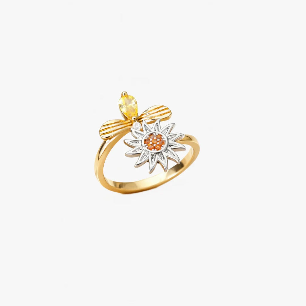 Justerbar fidgetring i guld med drejeligt solblomst-motiv og orange midte