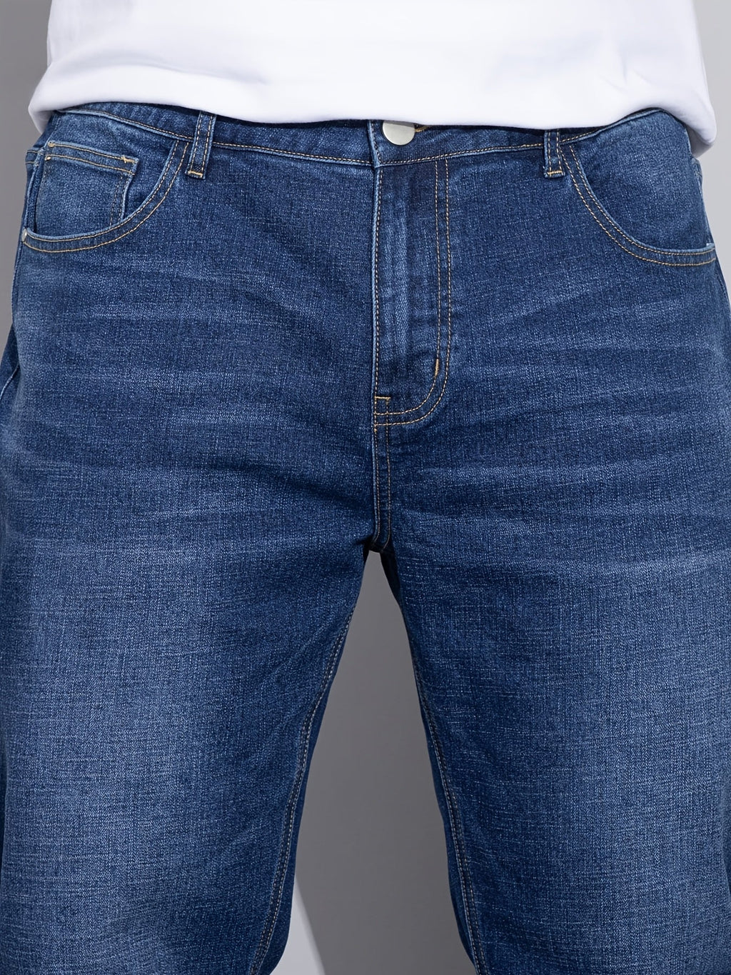 Blå jeans med lige ben, tæt på front med forlommer og dobbelte stikninger