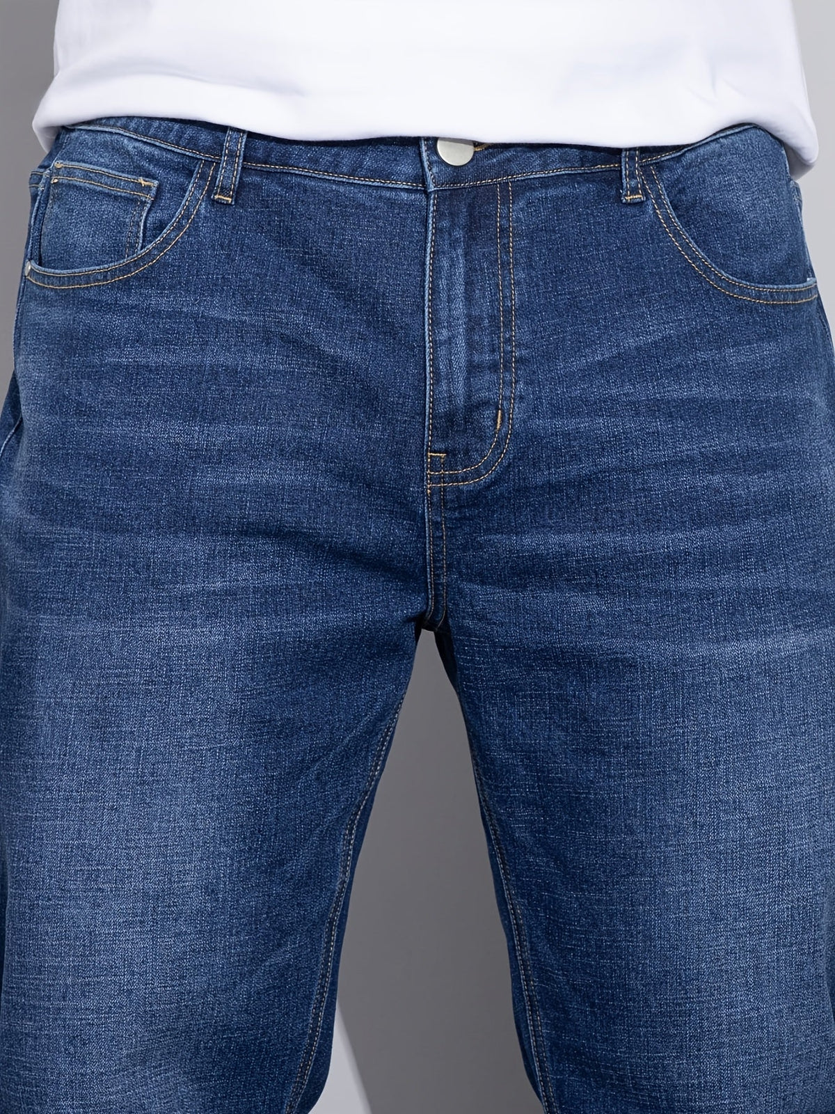 Blå jeans med lige ben, tæt på front med forlommer og dobbelte stikninger