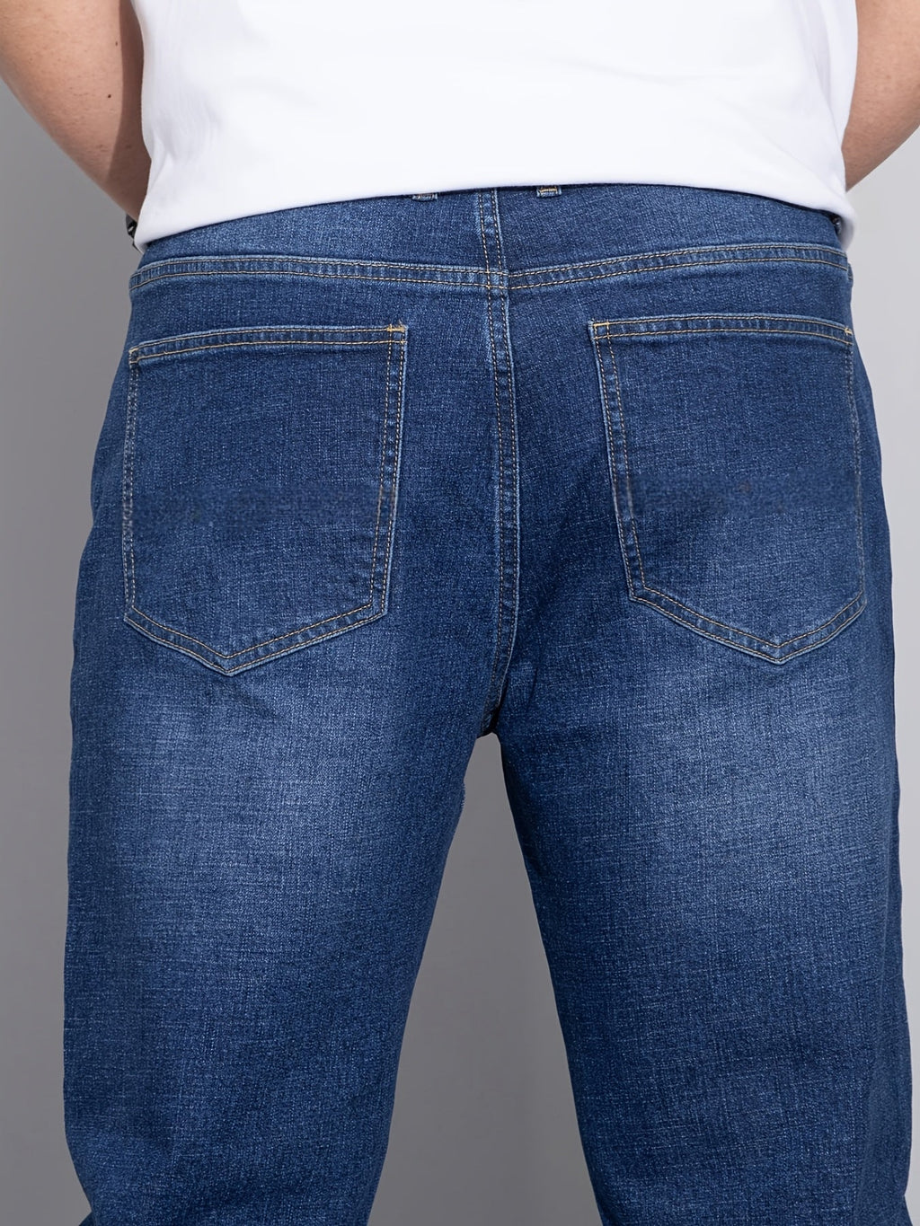 Blå jeans med lige ben, bagvisning med to baglommer og synlige stikninger
