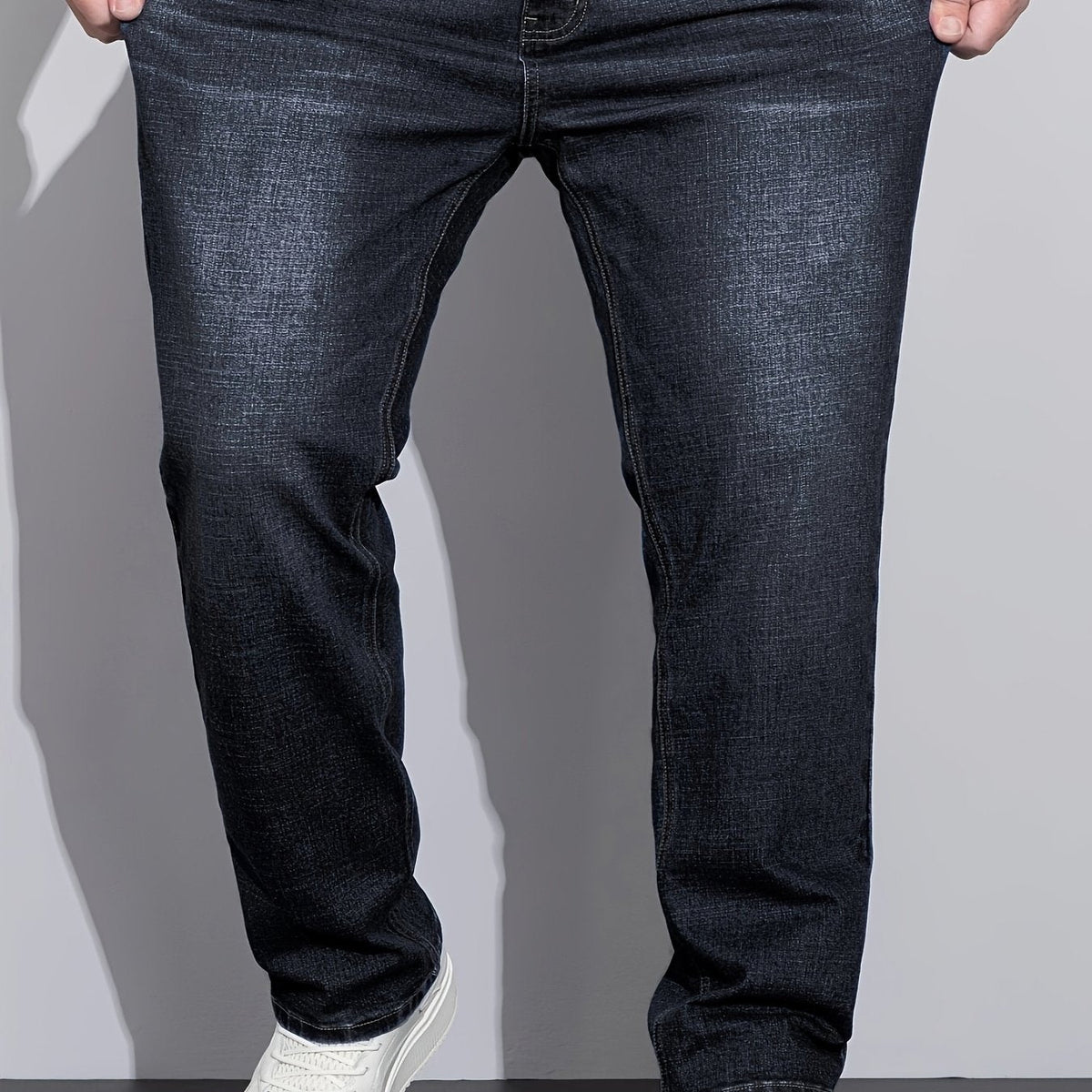 Sorte hverdagsjeans med lige ben, set forfra med knaplukning og stikninger