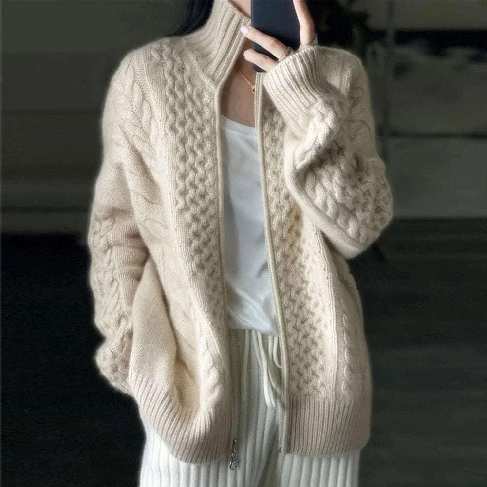 Beige kabelstrikket cardigan med lynlås og høj krave, grov strik.