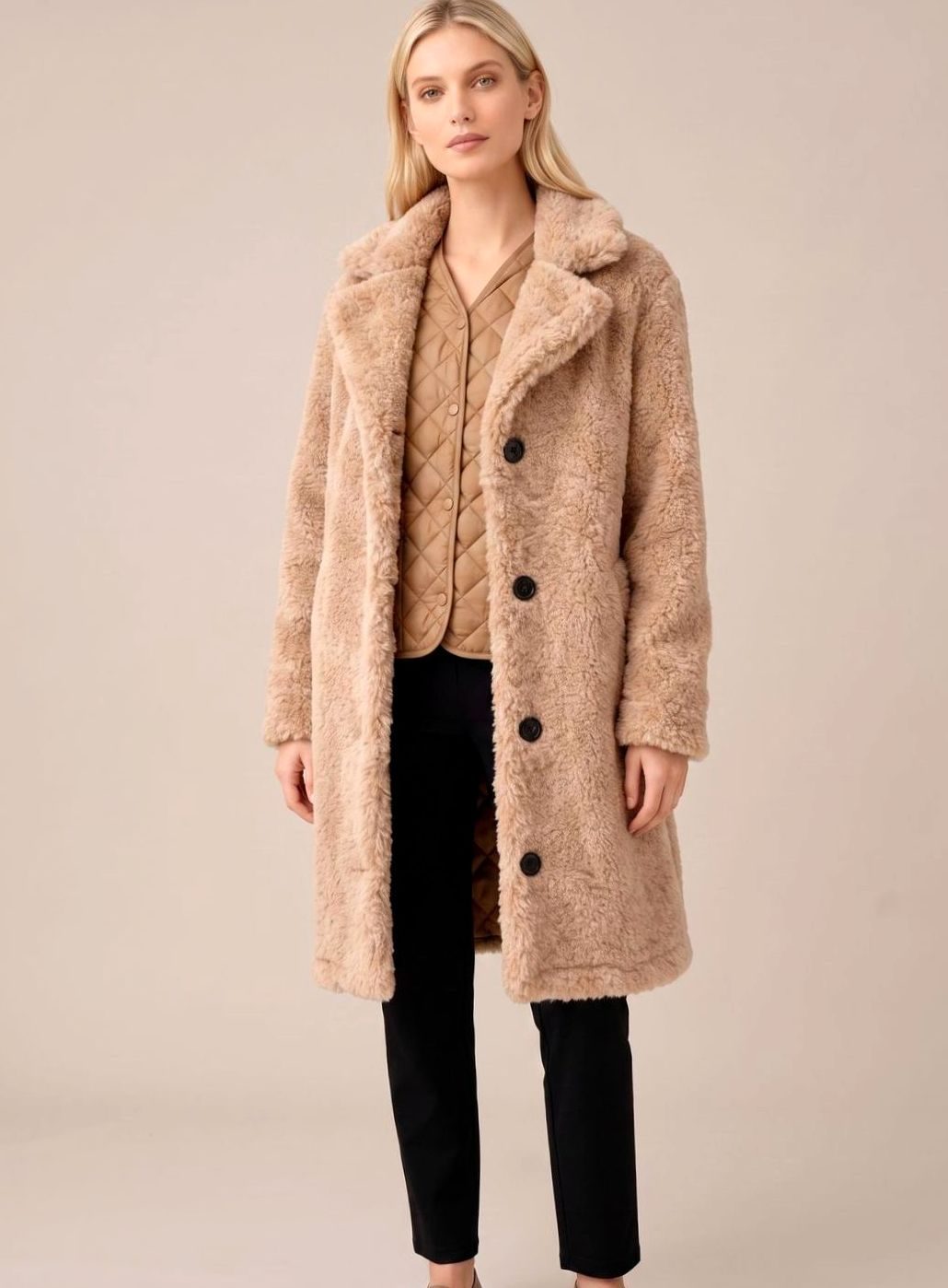 Beige teddyfrakke med spids revers og knaplukning, lommer og lang ærmelængde