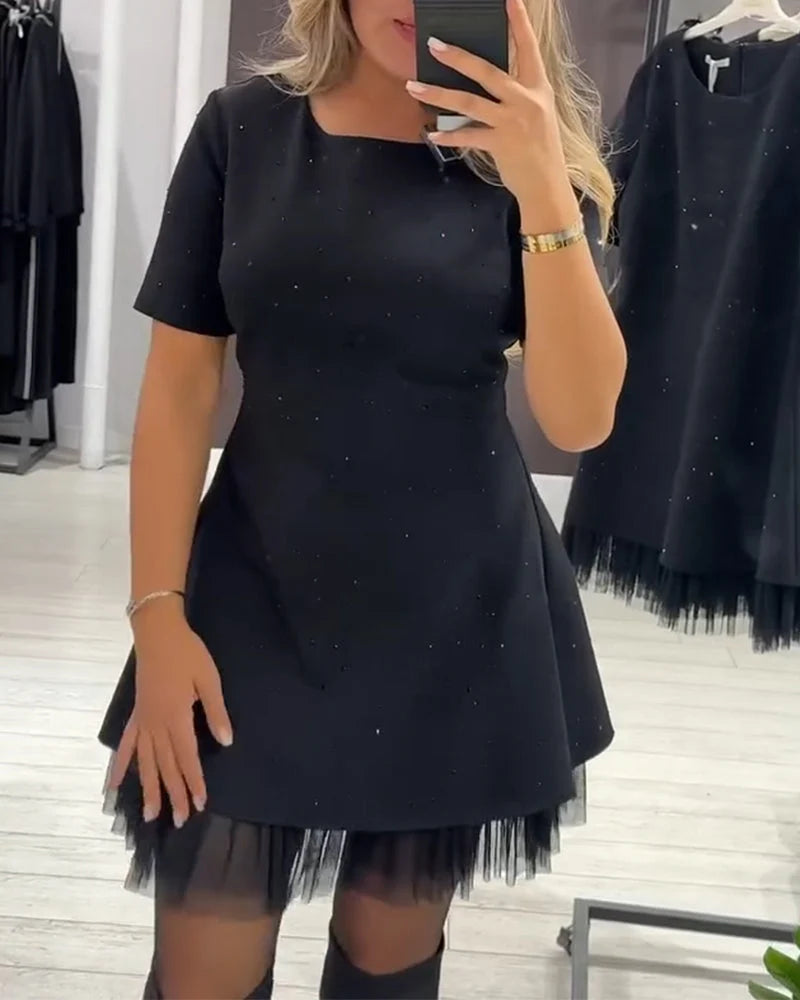 A-formet minikjole i sort med glimmerprikker og tylkant i nederste fald