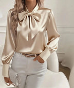 Beige bluse med stående krave, stor sløjfe og ballonærmer