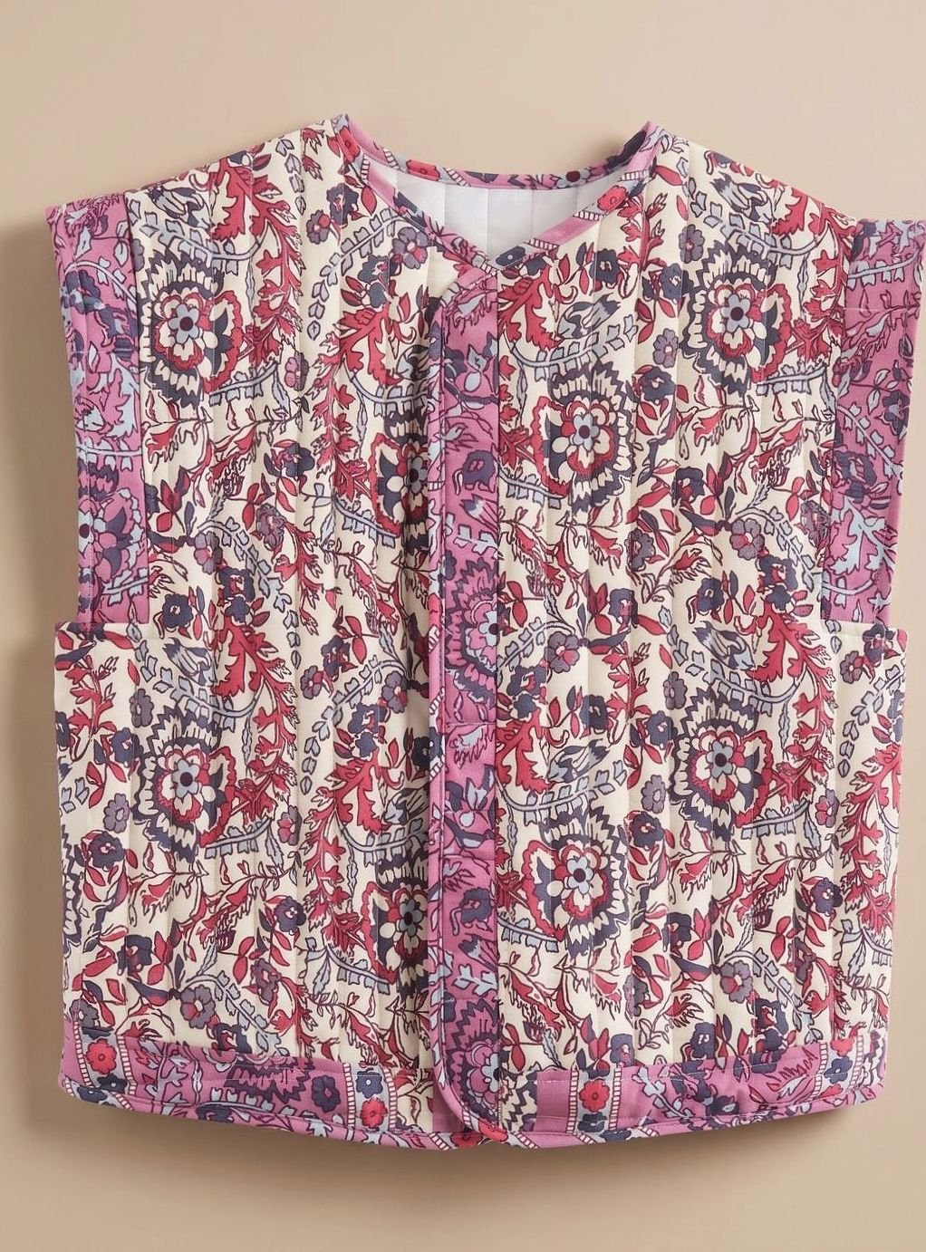 Quiltet vest med blomsterprint i rød og pink, kontrastkant og knaplukning