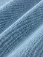 Nærbillede af lyseblåt denimstof med fin tekstur