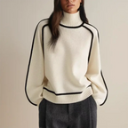 Oversized strikbluse i hvid med rullekrave og sorte kontrastkanter