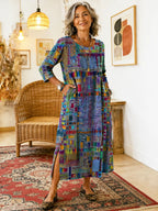 Flerfarvet maxikjole med patchwork-print og rund hals, synlig sideslid.