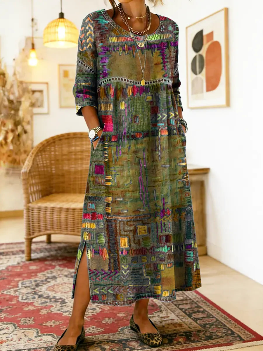Flerfarvet maxikjole med patchwork-print, rund hals og sideslid i kanten.
