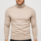 Beige strikbluse med rullekrave og ribstrikkede manchetter samt bundkant.