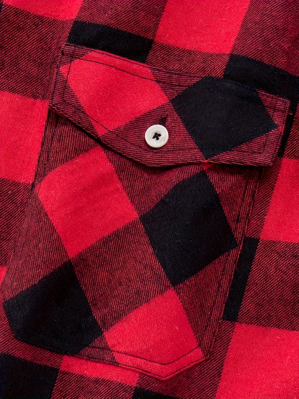 Detalje af rød og sort ternet flannelskjorte med brystlomme og knap
