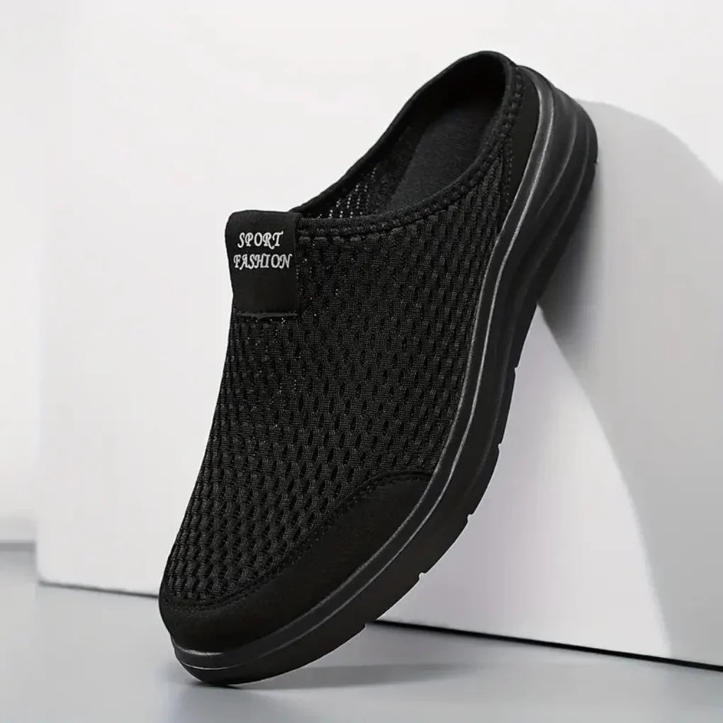 Sorte slip-on sneakers med åben hæl og meshoverdel, set fra siden
