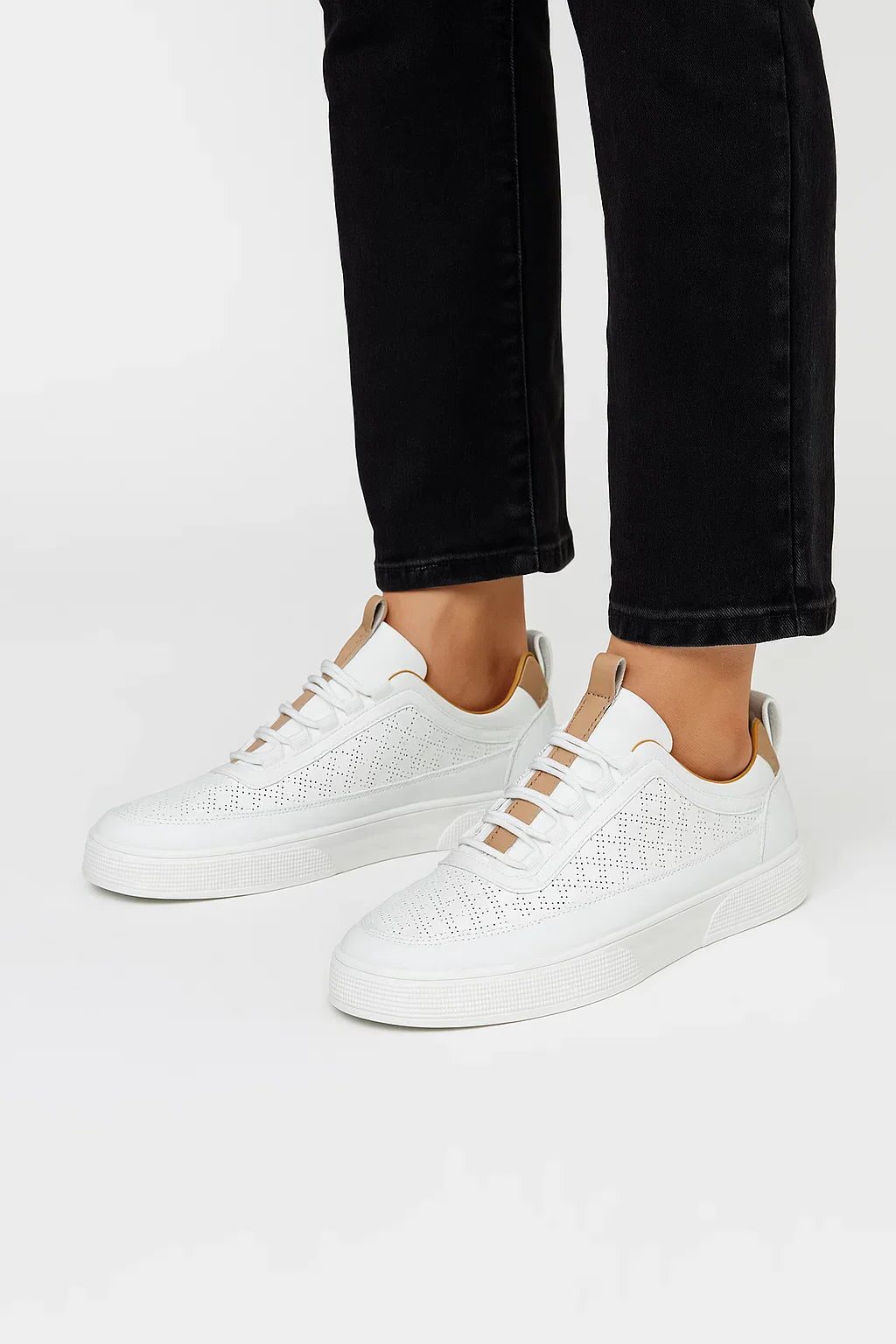 Hvide sneakers med hulmønster og polstret ankelkant, snørebånd.