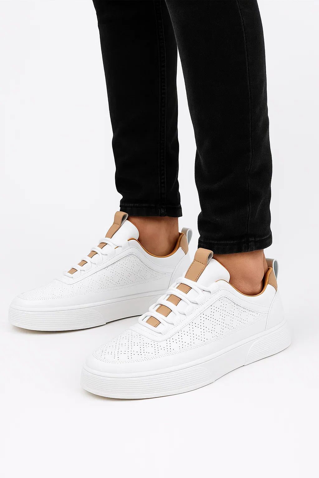Hvide sneakers med hulmønster, polstret ankelkant og snørebånd.