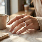 Guldfarvet ring med klar sten på fingeren