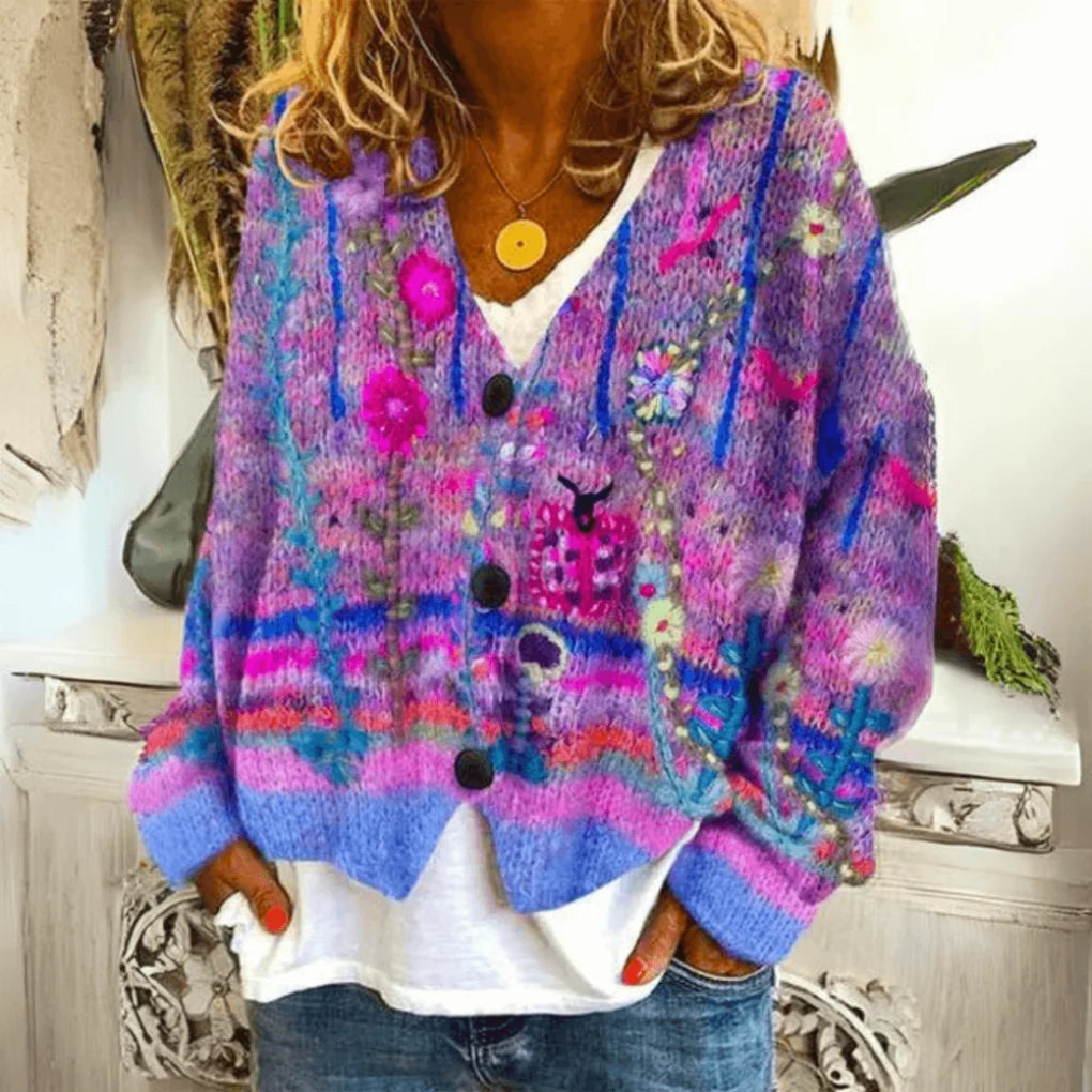 Lilla og flerfarvet strikket cardigan med V-hals, broderede blomster og sorte knapper.